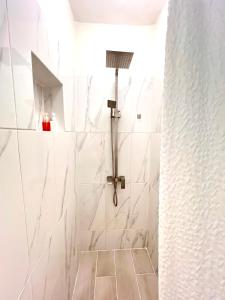 een badkamer met een douche met witte tegels bij La Dolce Vita Beachfront Apt 2 in Las Terrenas