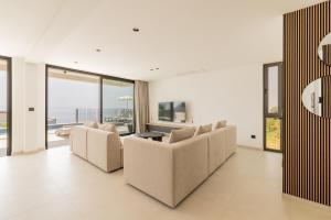 ein Wohnzimmer mit weißen Möbeln und großen Fenstern in der Unterkunft Villa Reina in Makarska