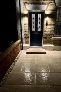 a blue front door of a brick house at night at Adrian Cottage in Abbots Langley