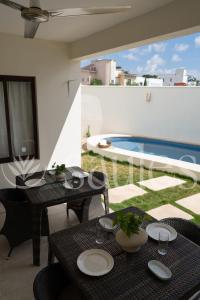 a patio with tables and chairs and a pool at Saules Sueño in Cancún