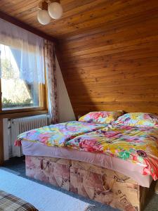 a bed in a room with a wooden ceiling at Chata na Polane in Vyšné Hágy