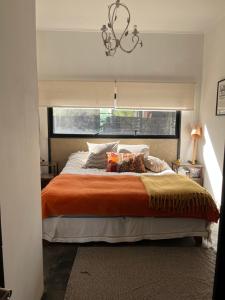 a bedroom with a large bed with an orange blanket at Cajanegra in El Cerrillo