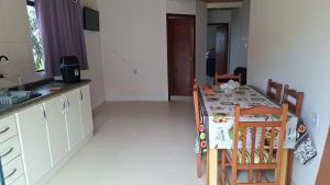 a kitchen with a table and chairs and a kitchen with a table and a kitchen at Aluguel diária in Florianópolis