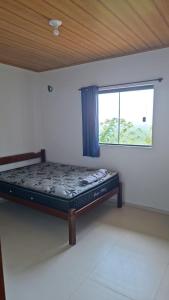 a bed in a room with a window at Aluguel diária in Florianópolis
