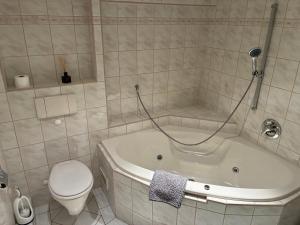 een badkamer met een wit bad en een toilet bij Ferienwohnung Flohblick in Floh