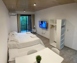 a room with two beds and a tv in it at Studio 44 Escobar in Belén de Escobar