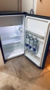 an open refrigerator with bottles of water in it at Studio 44 Escobar in Belén de Escobar
