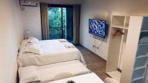 two beds in a room with a window at Studio 44 Escobar in Belén de Escobar