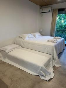 two beds sitting next to each other in a bedroom at Studio 44 Escobar in Belén de Escobar +16 photos