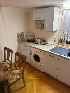een keuken met een wasmachine en een tafel en stoelen bij Ferienwohnung Flohblick in Floh