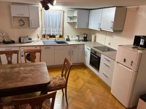 een keuken met witte kasten en een tafel en een eetkamer bij Ferienwohnung Flohblick in Floh