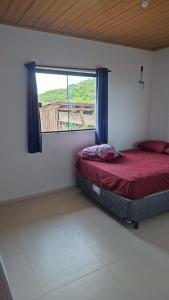 a small bedroom with a bed and a window at Aluguel diária in Florianópolis