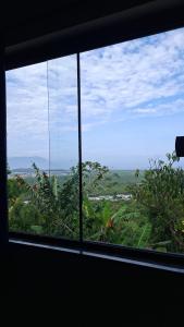 a window with a view of a field of plants at Aluguel diária in Florianópolis