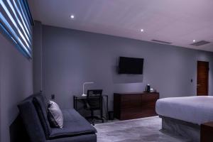 a bedroom with a bed and a chair and a desk at Hotel La Querencia in Río Verde