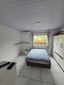 a small bedroom with a bed and a window at Bruna in Florianópolis
