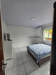 a bedroom with a bed and a television in it at Bruna in Florianópolis