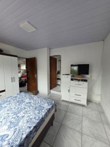 a bedroom with a bed and a flat screen tv at Bruna in Florianópolis +3 photos