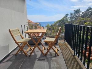a wooden table and two chairs on a balcony at Blue Horizon Apartments in Varadouro