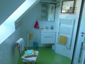 een badkamer met een wastafel en een stoel in een kamer bij Villa Lou Ann in Pontchâteau