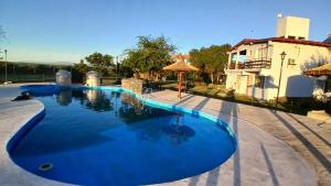 a swimming pool with blue water in front of a house at DUPLEX Stadium in Tanti