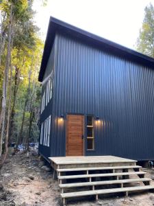 un edificio blu con una porta in legno e scale di Hotel Río Puelo a Puelo