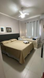 een slaapkamer met twee bedden en een plafondventilator bij Suíte Aconchegante in Belém