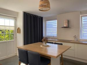 a dining room with a wooden table and chairs at Chez Aurel et Nico in Frélinghien