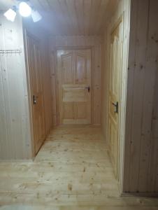 an empty room with two doors and a wooden floor at Микуличин на долоні 2 in Mykulychyn +13 photos