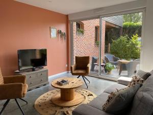 a living room with a couch and a tv at Chez Aurel et Nico in Frélinghien