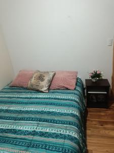 a bed in a room with a pillow on it at MyE in Frutillar