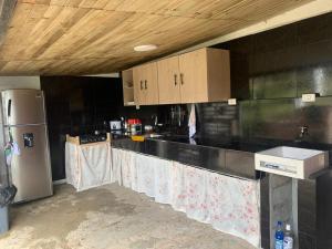 a kitchen with black counter tops and a refrigerator at El Edén in Guarne