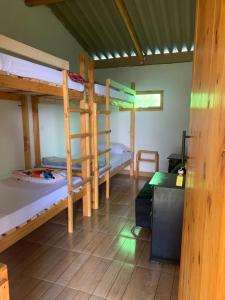 a room with three bunk beds and a desk at El Edén in Guarne