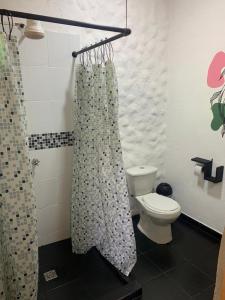 a bathroom with a toilet and a shower curtain at El Edén in Guarne +13 photos