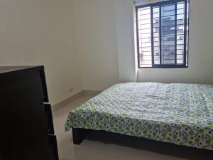 a bedroom with a bed and a window at M Ali House in Sylhet