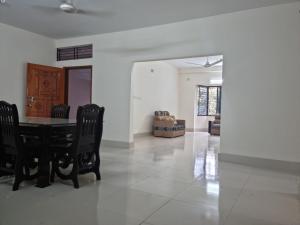 a dining room with a black table and chairs at M Ali House in Sylhet