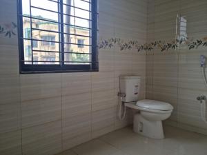 a bathroom with a toilet and a window at M Ali House in Sylhet +1 photo