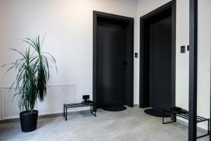 a room with two black doors and a potted plant at Felicita Deluxe Apartments with Free Parking in Sarajevo