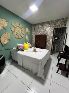 een kamer met een bed met een tafel en een piano bij Pousada e Restaurante Morena Raiz in Olinda