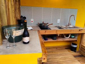 a bottle of wine sitting on a shelf next to a sink at SuÍte MAR Espaço Kombucha Paraty in Paraty