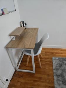 a wooden desk with a chair next to a room at Chambre idéalement située in Villeurbanne
