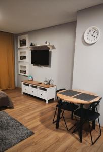 een woonkamer met een tafel en een tv bij Old Slabada Apartments in Kaunas