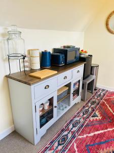 a white cabinet with a microwave on top of it at Four Seasons B&B, Ground floor room, private bathroom, 3rd floor loft living area & self serve continental breakfast in Pitlochry