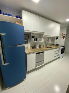 een keuken met witte kasten en een blauwe koelkast bij Suíte Aconchegante in Belém +9 foto's