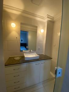 een badkamer met een wastafel en een spiegel bij Suíte Aconchegante in Belém
