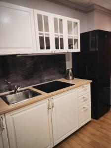 een keuken met witte kasten en een spoelbak bij Old Slabada Apartments in Kaunas +12 foto's