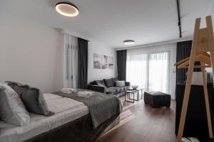 a bedroom with a bed and a living room at Felicita Deluxe Apartments with Free Parking in Sarajevo +52 photos