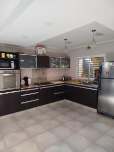 a kitchen with brown cabinets and a stainless steel refrigerator at Casa Ramirez in Posadas
