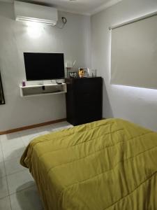 a bedroom with a bed and a flat screen tv at Casa Ramirez in Posadas