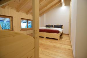 a bedroom with a bed in a room with wooden floors at Malga Valmaggiore in Bellamonte
