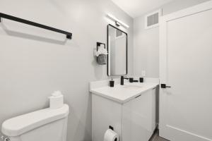 a white bathroom with a sink and a mirror at LUX 1 BD Apartment In Union Market in Washington, D.C.